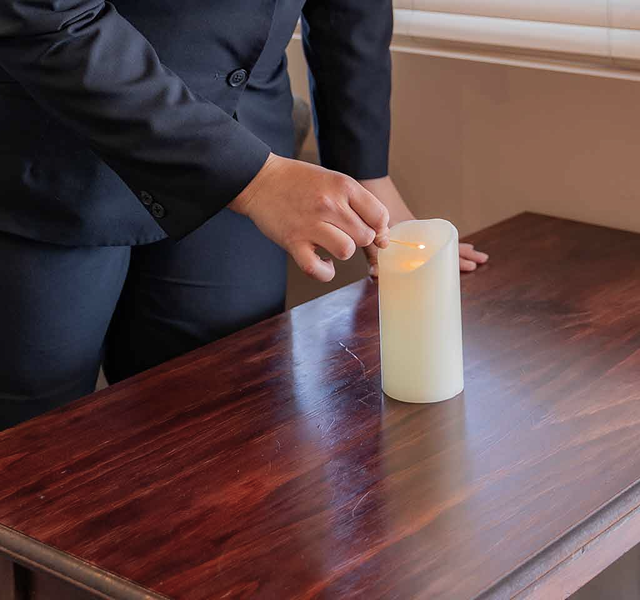 funeral director lighting a candle